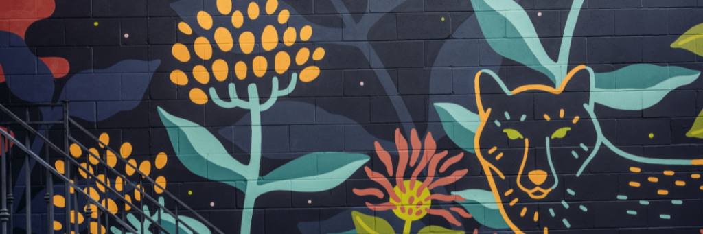 Ilustracja do artykułu, przedstawiająca kolorowy mural z roślinami i wilkiem