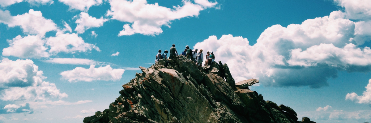 Zdjęcie przedstawia grupe osób na szczycie góry.