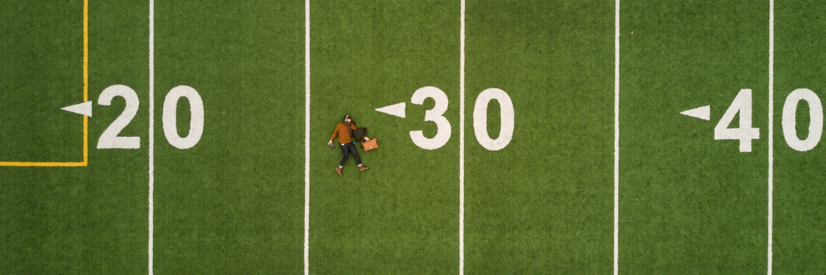 Zdjęcie przedstawia osobę leżącą na boisku do futbolu.