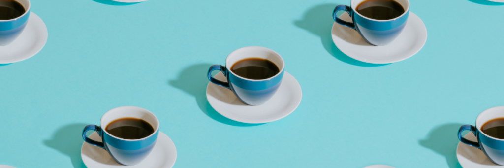 Zdjęcie przedstawia niebieskie filiżanki z kawą ustawione równolegle do siebie.